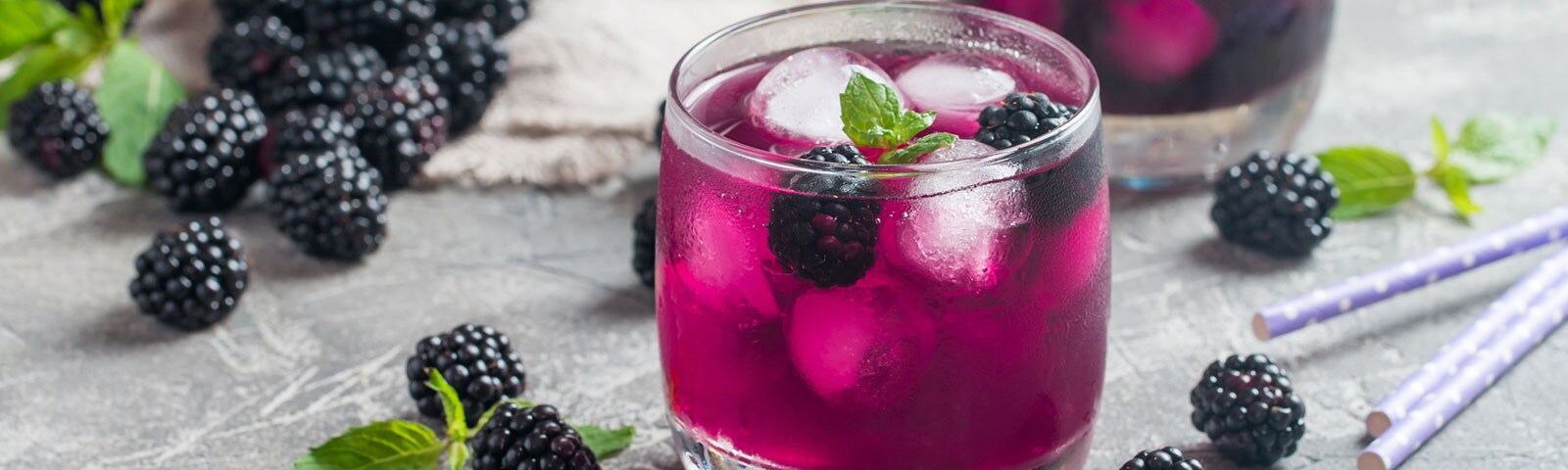 Magenta colored drink with ice cubes and blackberries Magenta colored drink with ice cubes and blackberries