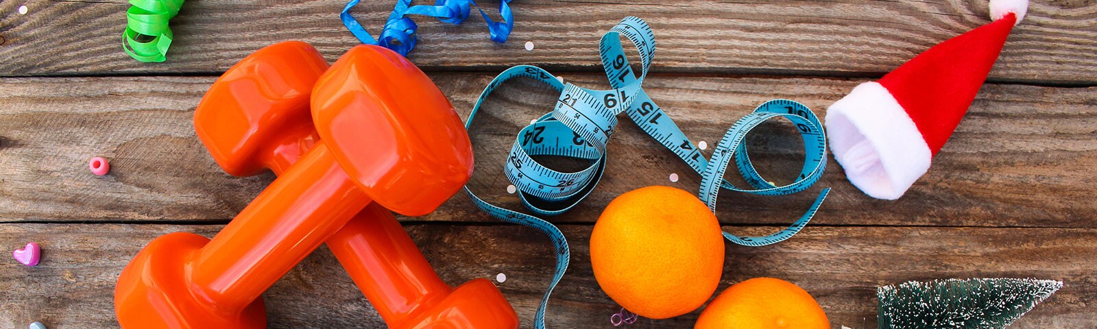 Weights and oranges on a wooden table to stay healthy