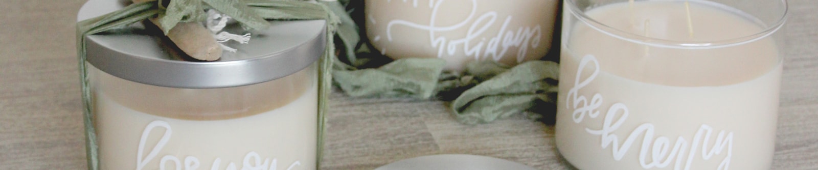 Close crop of white candles with silver lids and personalized messages written on the glass