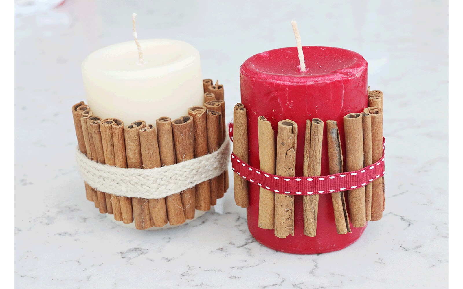 Red candle wrapped in cinnamon sticks held in place with ribbon sits inside of a white lantern with glass windows Red candle wrapped in cinnamon sticks held in place with ribbon sits inside of a white lantern with glass windows