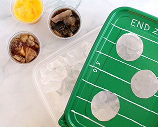Finished tray: football-themed green rectangle container lid over ice that's ready to serve drinks Finished tray: football-themed green rectangle container lid over ice that's ready to serve drinks