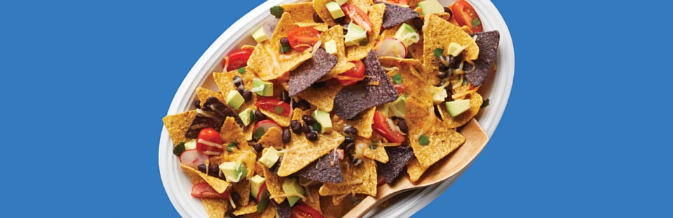 Microwave nachos with tomatoes, black beans, cheese and diced avocados